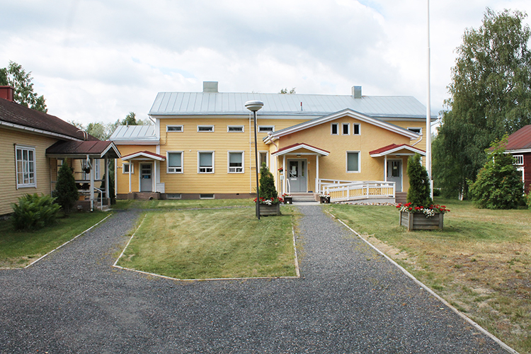 Pappila Pappilan keltainen rakennus ja pihapiiriä